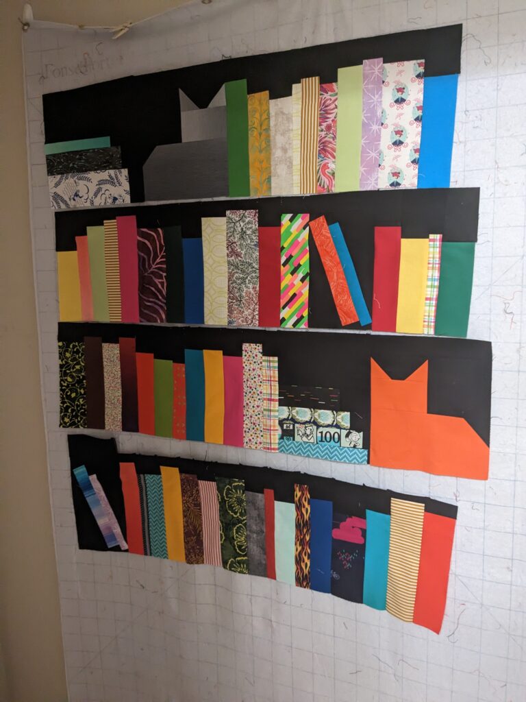 Rows of the book case quilt all ready for the brown border.