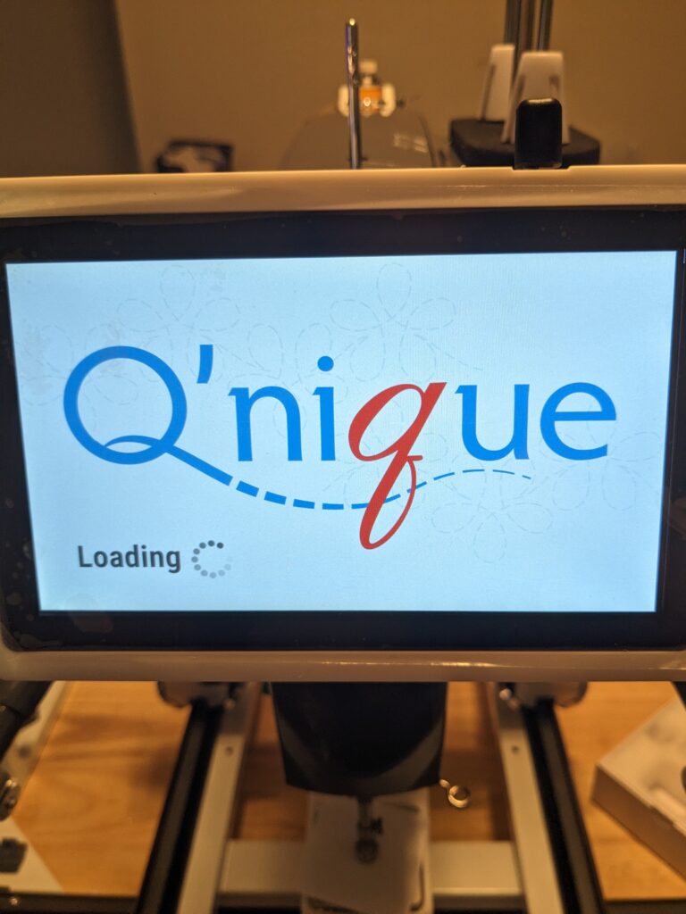 The display for the 19x Elite turning on for the first time. It says "Q'nique" and "Loading".