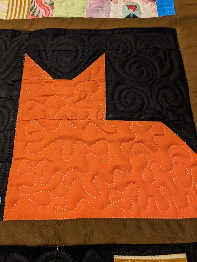 Close up of the orange cat block in the bookcase quilt.