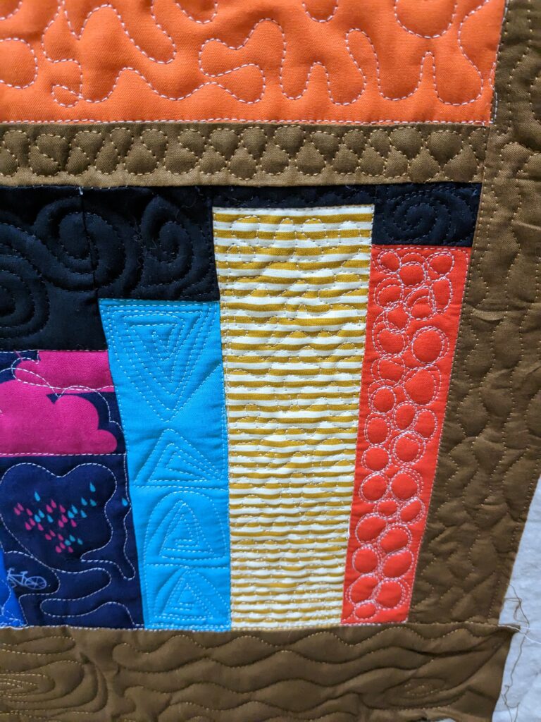 A closeup of my bookcase quilt showing my first attempt at pebbles.