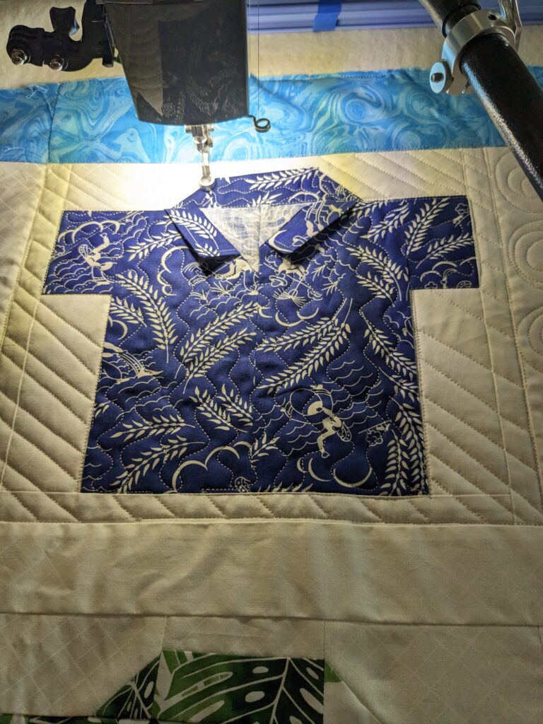 A shirt block with straight line quilting in the background and waves quilted in the shirt.