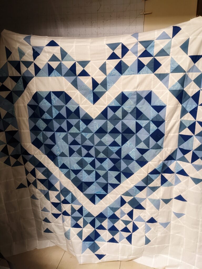 The entire scrappy blue Exploding Heart Quilt top prior to quilting.