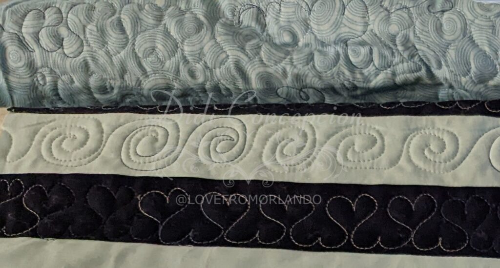 A row of quilted hearts and a row of quilted swirls on the Through Love quilt.