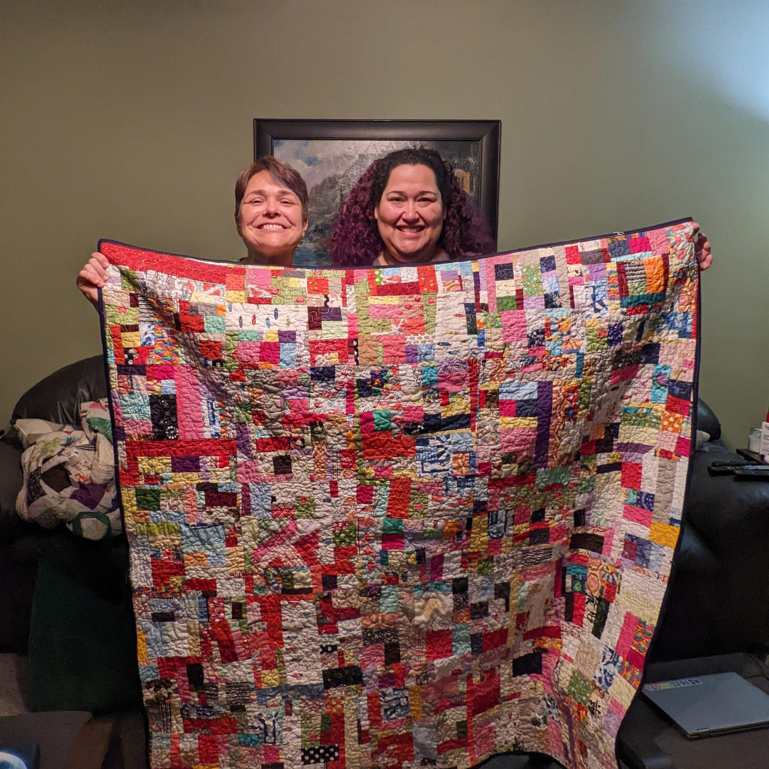 My friend and I holding up the finished crumb quilt in front of us.