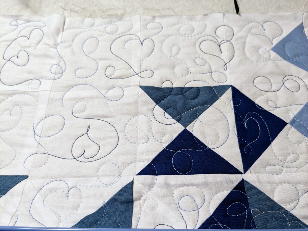A portion of the quilt on my Cutie frame quilted with a loopy heart meander.