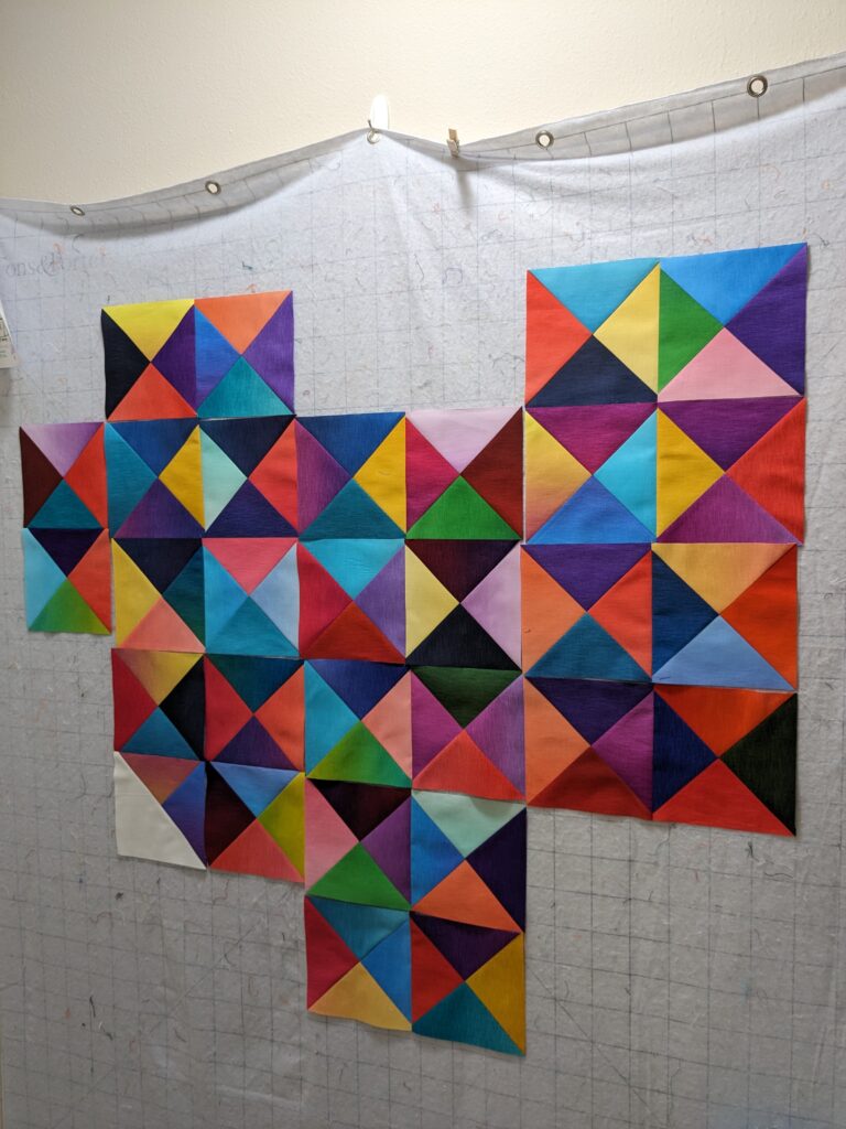 Quarter Square Triangle blocks on my design wall.