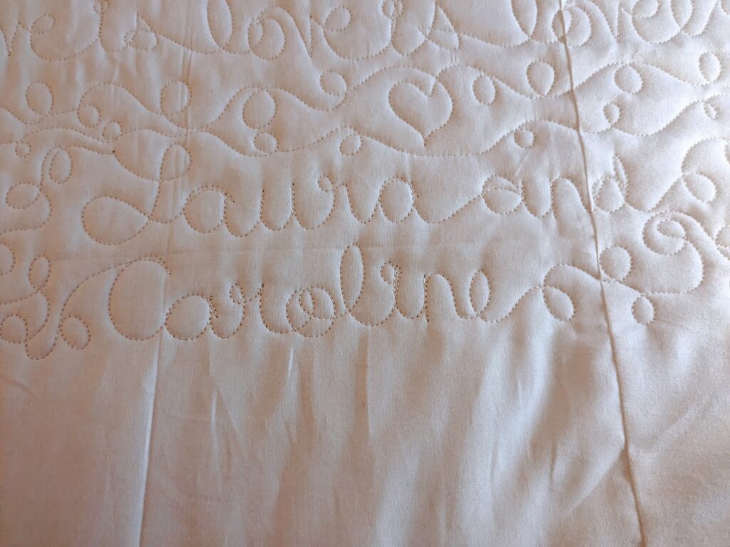 Closeup of the quilting that says "Laura and Caroline".