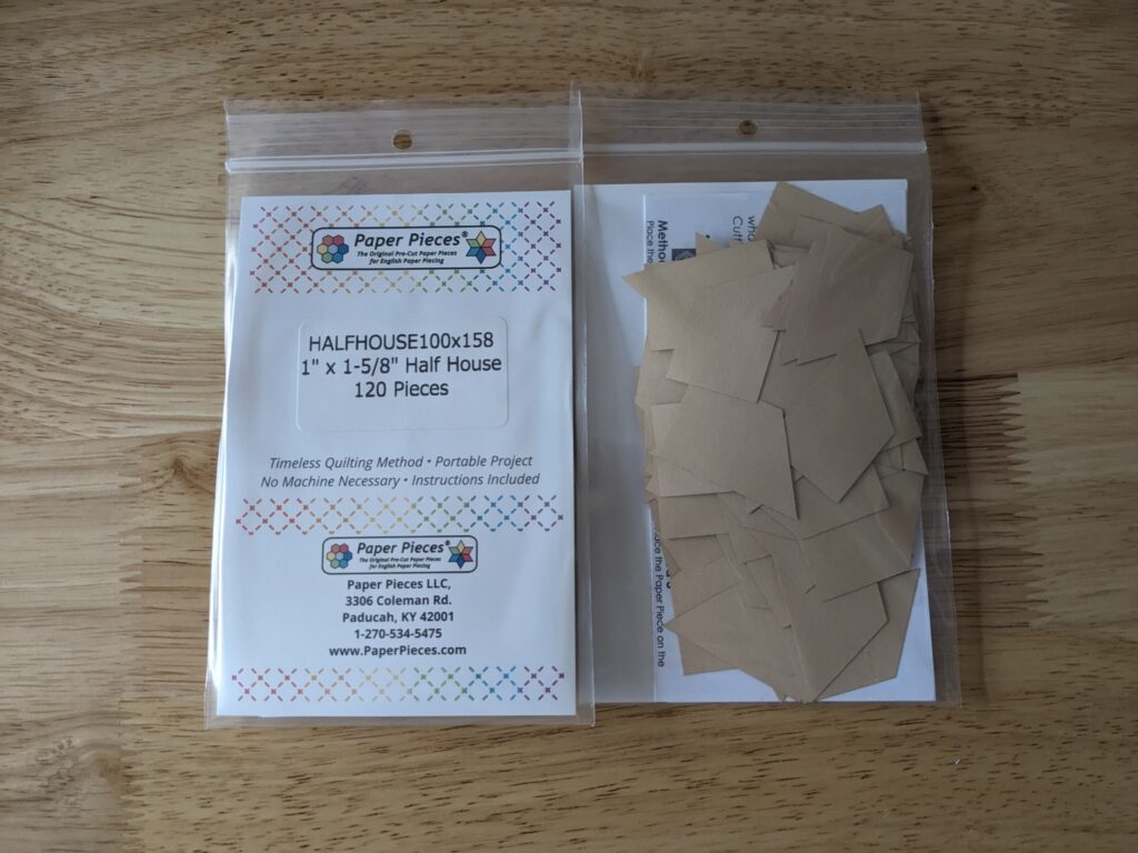 Two packs of half house paper pieces. One showing the front and the other showing the back of the package.