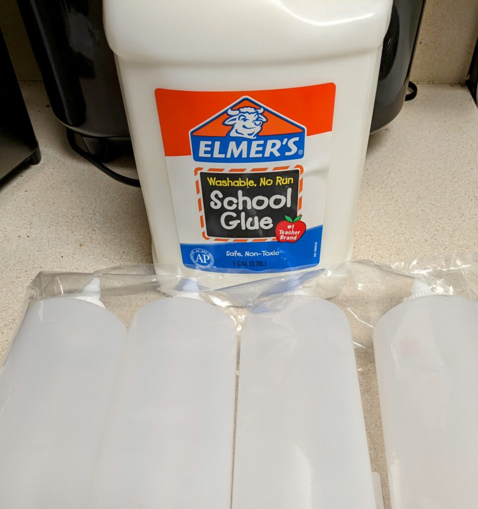 A large jug of Elmer's Washable School Glue and 4 empty squeeze bottles.